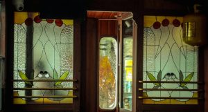 Vitraux fleuris et boiseries dans un wagon de train vintage de luxe