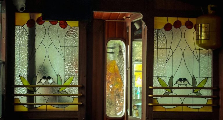 Vitraux fleuris et boiseries dans un wagon de train vintage de luxe