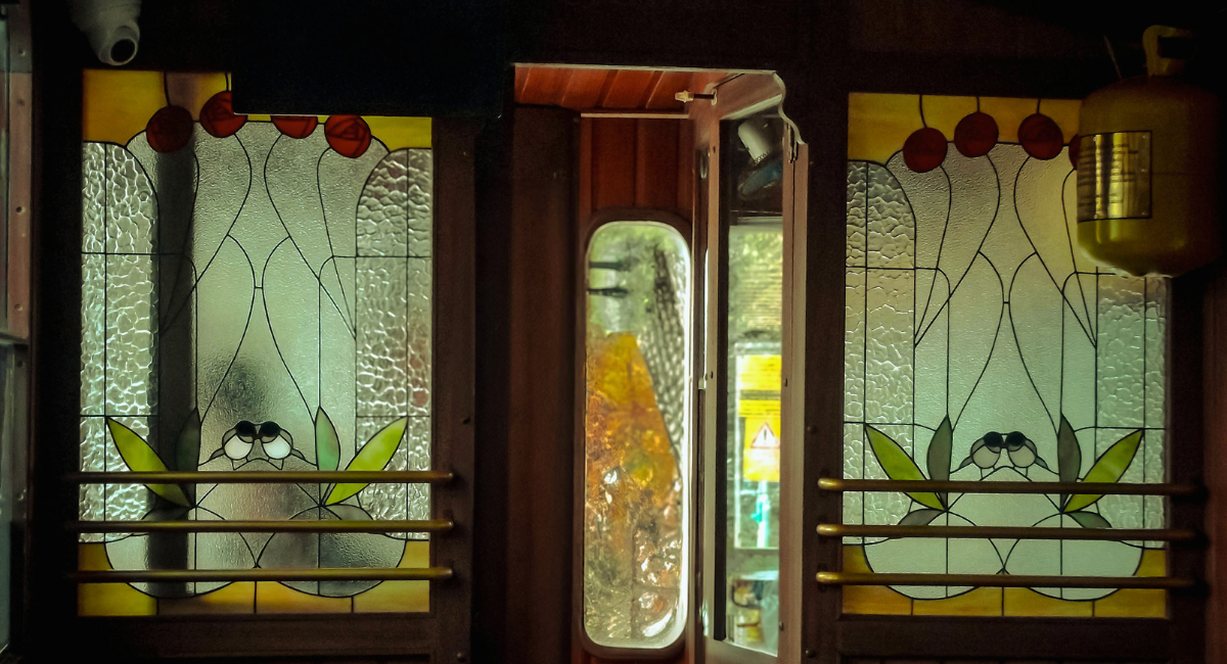 Vitraux fleuris et boiseries dans un wagon de train vintage de luxe