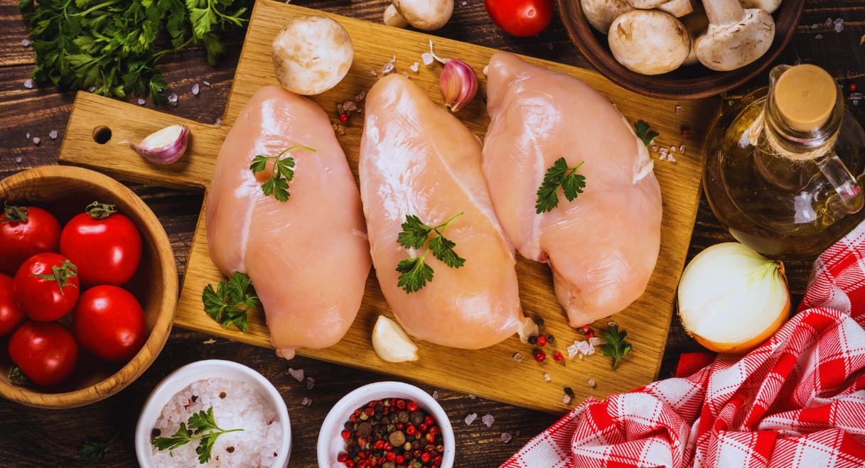 Trois blancs de poulet crus entoures d ingredients