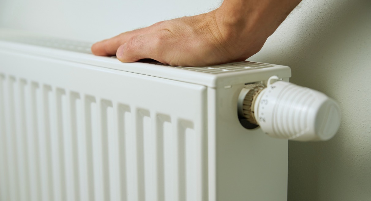 Main posee sur un radiateur blanc pour verifier sa temperature